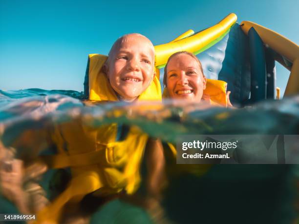 happy caucasian mother and son having fun during summer holidays at the seaside - happy holidays family stock pictures, royalty-free photos & images