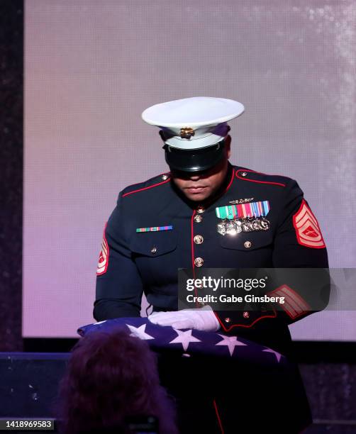 Marine Corps gunnery sergeant Larry Shead presents a folded American flag to Brenda Glur-Spinks during Leon Spinks celebration of life and memorial...