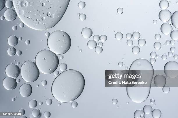 oil with bubbles on grey monochrome background - oil flow stockfoto's en -beelden