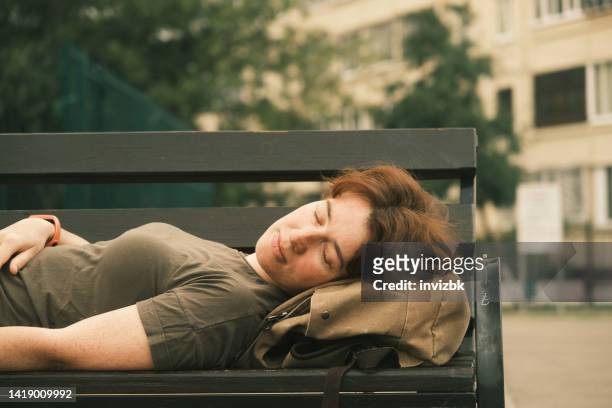 woman is sleeping on the bench - khaki stock pictures, royalty-free photos & images