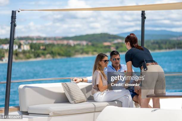 stewardess serving cocktail to couple - luxury yachts stockfoto's en -beelden