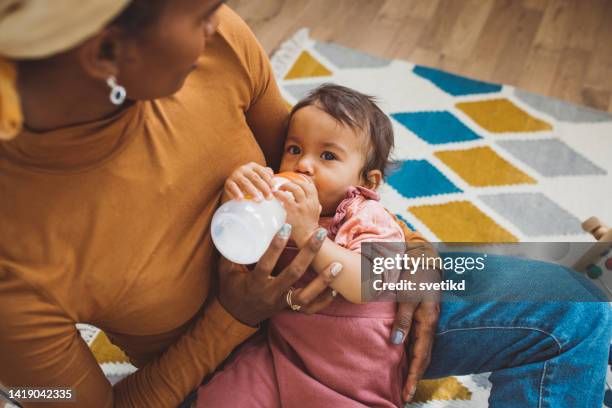 young mother with baby at home - feeding stock pictures, royalty-free photos & images