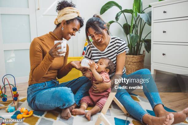schwules paar mit baby zu hause - toddler milk stock-fotos und bilder