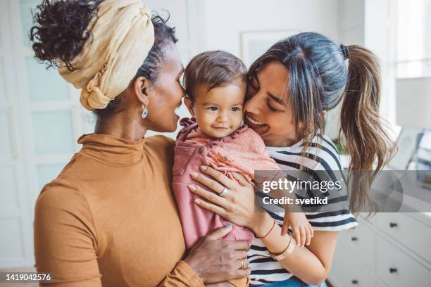 couple gay avec bébé à la maison - bebe metisse photos et images de collection
