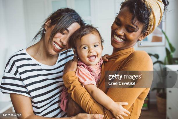 gay couple with baby at home - lesbian mom stock pictures, royalty-free photos & images