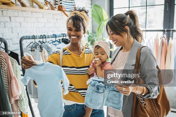 gay couple in shopping with baby - baby boutique stock pictures, royalty-free photos & images