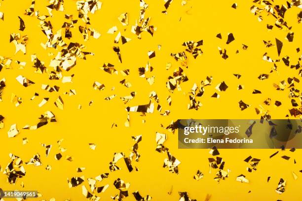 festive yellow background with gold sparkles. - confetti gold ストックフォトと画像