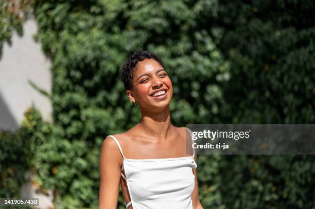 cheerful girl laughing by the hedge - skin tone stock pictures, royalty-free photos & images