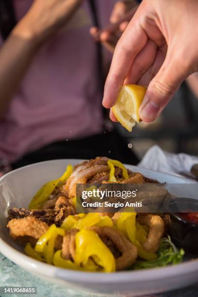squeezing lemon over calamari - newport rhode island stock pictures, royalty-free photos & images