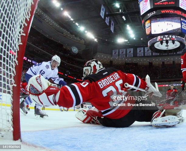 Tyler Bozak of the Toronto Maple Leafs watches a shot sail past Martin Brodeur of the New Jersey Devils at the Prudential Center on March 23, 2012 in...