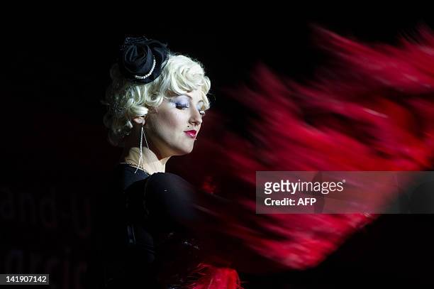 Dancer starts performing during a strip dance contest at the "Erotika Fair" in Sao Paulo, Brazil on March 25, 2012.The annual fair of products and...