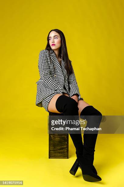 fashionable woman in front of plain background - thigh high boot stock pictures, royalty-free photos & images
