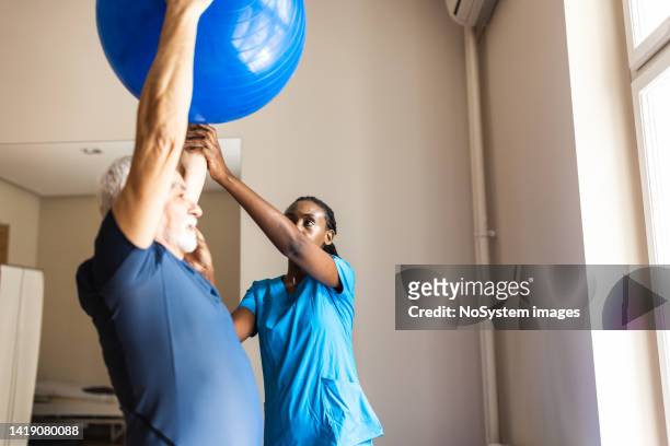 senior mane at the physical therapy centre - fitness ball stock pictures, royalty-free photos & images