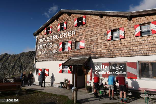 Alpine hikers prepare to embark from the Innsbrucker Hütte mountain hut in the Stubai Alps mountain range on August 26, 2022 near Neustift im...
