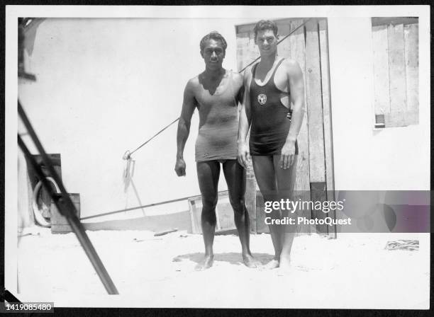 Portrait of American Olympic gold medalists Duke Kahanamoku and Johnny Weissmuller as they pose together at Waikiki Beach, Honolulu, Hawaii, circa...