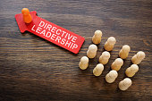 Directive leadership concept. Arrow and wooden figurines.