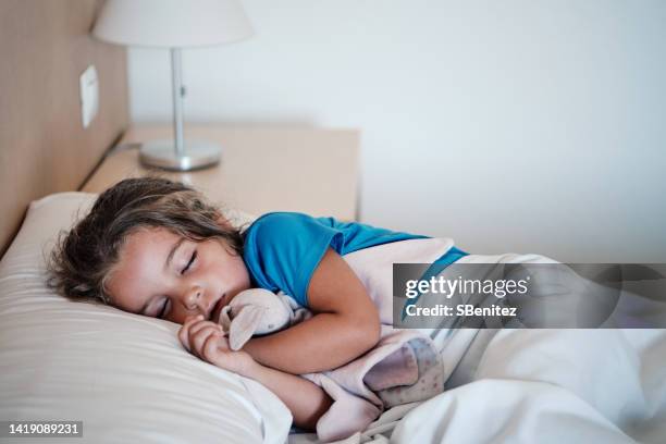 high angle view of baby sleeping on bed at home - bedside table kid asleep stock pictures, royalty-free photos & images