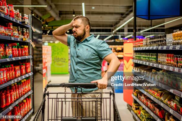 un homme contrarié par l’augmentation des prix des denrées alimentaires - angry customer photos et images de collection