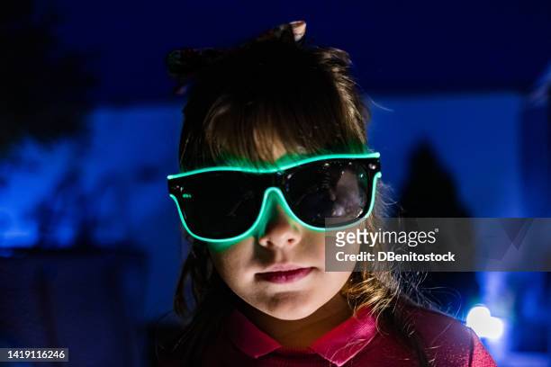 young girl with glasses illuminated with green led light, in the middle of the night with the light of the full moon, serious. party, technology, futuristic, halloween, carnival and bizarre concept. - cyber punk girl stock pictures, royalty-free photos & images