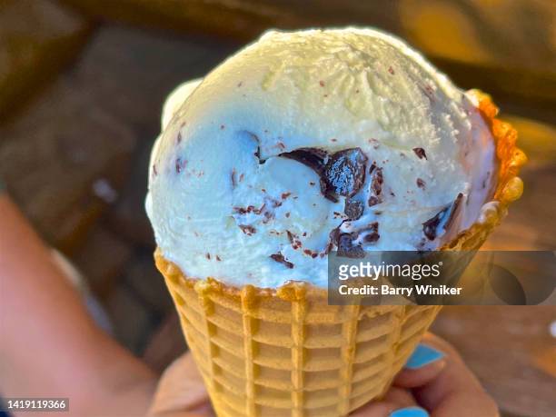 close-up of ice cream cone  held by woman's two hands - dulce de azúcar y mantequilla fotografías e imágenes de stock