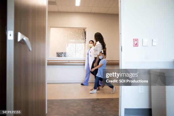 pediatrician escorts family - sick child and mother in hospital stock pictures, royalty-free photos & images