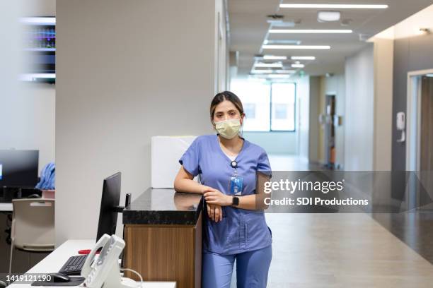 female doctor looks at the camera - nurse station stock pictures, royalty-free photos & images