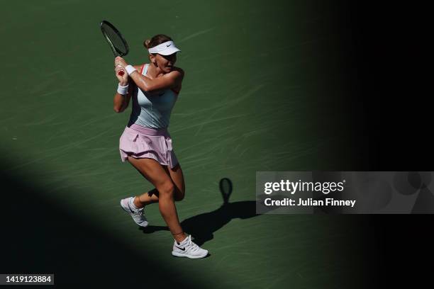 Simona Halep of Romania returns a shot against Daria Snigur of Ukraine during the Women's Singles First Round on Day One of the 2022 US Open at USTA...