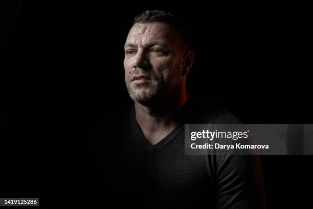 portrait of handsome brutal man on black isolated background. serious brunette middle aged man in black pullover. - portrait dark background stock pictures, royalty-free photos & images