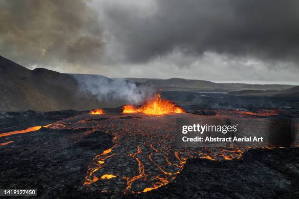 lava erupting from a volcano shot from a drone, iceland - volcano stock-fotos und bilder