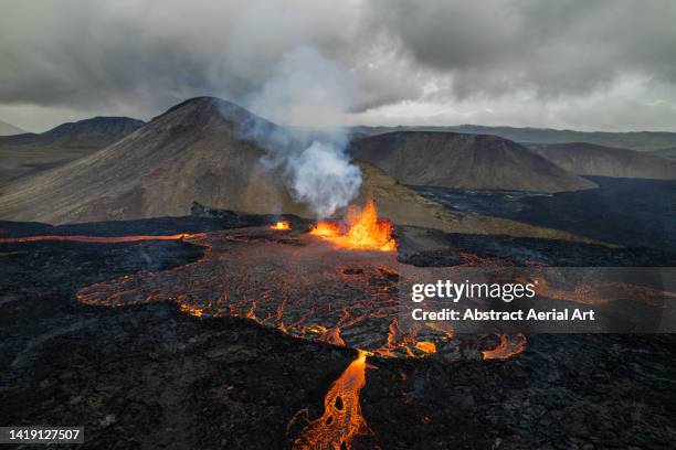 drone point of view showing lava erupting from a volcano, iceland - fagradalsfjall stock pictures, royalty-free photos & images