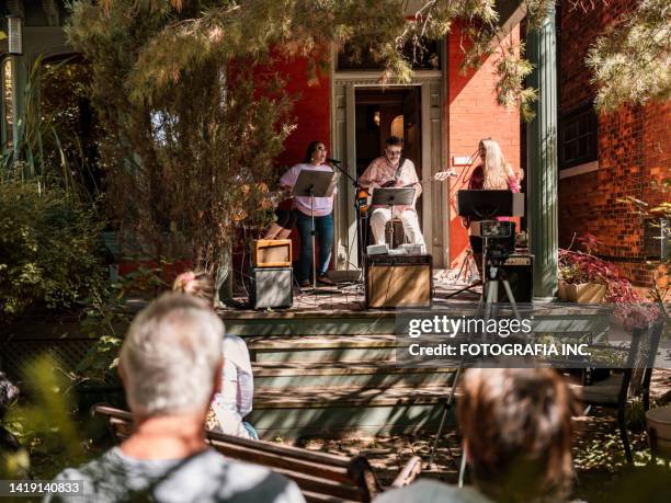 band of mature people playing music and singing outdoors - veranda stock pictures, royalty-free photos & images