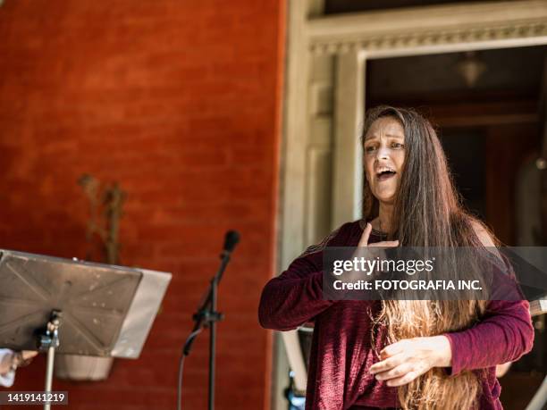 middle age woman singing with sign language outdoors - sign language stock pictures, royalty-free photos & images