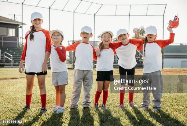 team of elementary age children playing little league baseball in local park - t ball game stock pictures, royalty-free photos & images