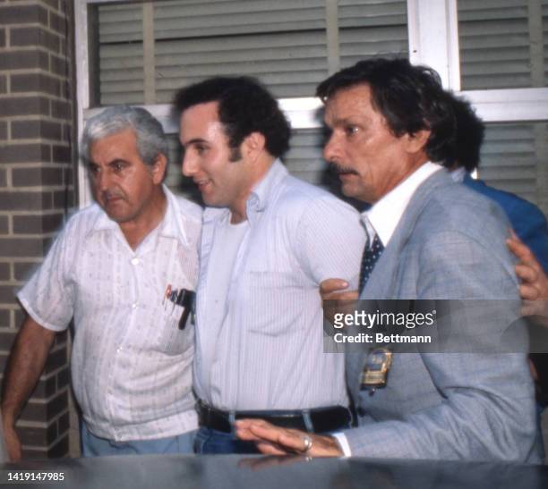 Smiling David Berkowitz is taken from a police car for booking prior to criminal court arraignment in connection with the "Son of Sam" killings. The...