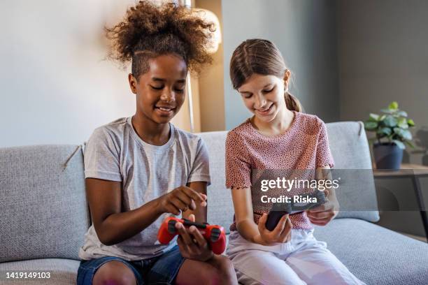 cute girls playing video games at home - spelregels stockfoto's en -beelden