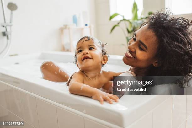 mother and baby bathing - bathing stock pictures, royalty-free photos & images