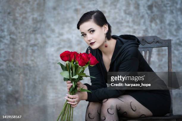 portrait of a teenage girl holding roses. - young goth girls photos et images de collection