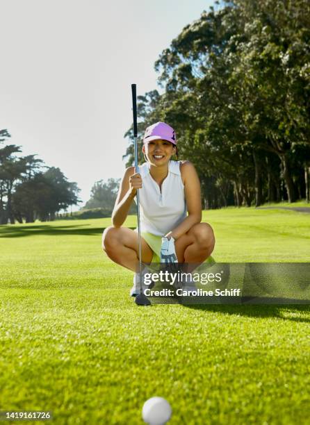 asian woman lining up a shot on the golf course - young golfer stock pictures, royalty-free photos & images