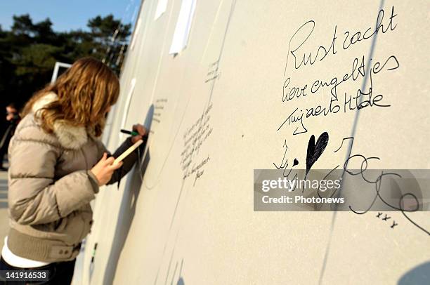 Members of the public sign a board outside the Soeverein Arena during the funeral ceremony for those who died in the Sierre Bus Crash on March 22,...