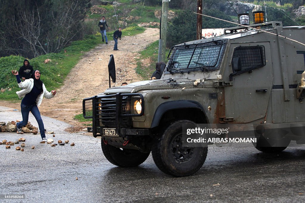 A Palestinian protester throws a stone t