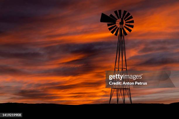 silhouette of a wind pump, windmill at sunset. - outback windmill bildbanksfoton och bilder