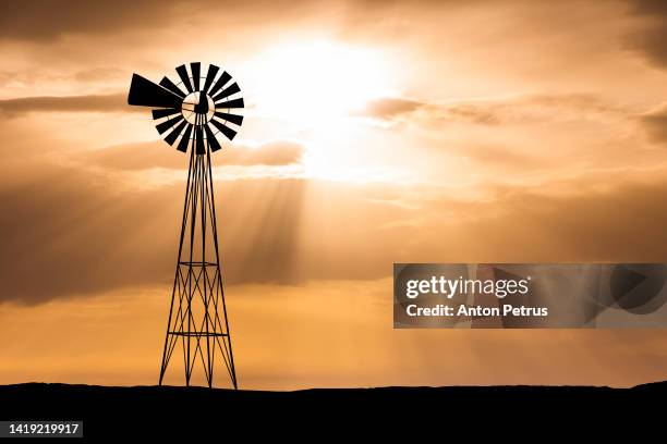 silhouette of a wind pump, windmill at sunset. - 工業用風車 ストックフォトと画像