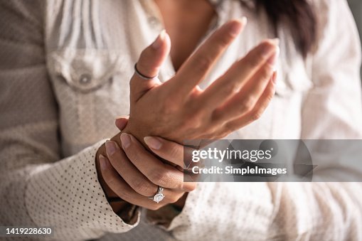 Detail of a woman holding her hand in pain caused by a carpal tunnel. Detail of a woman holding her hand in pain caused by a carpal tunnel.