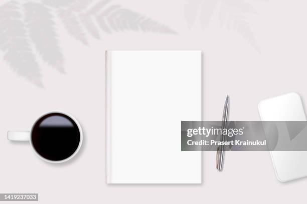 blank white book , pen, smartphone and black coffee on white table - mug mockup stock pictures, royalty-free photos & images