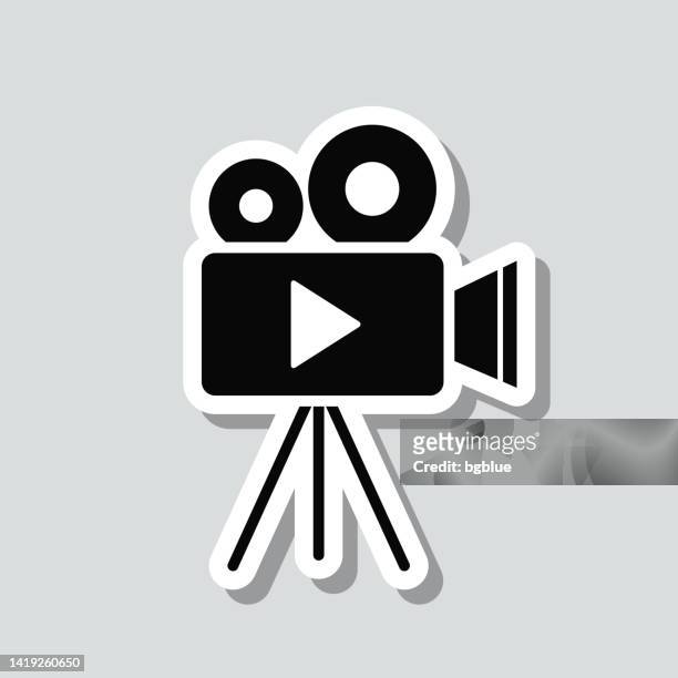 video camera with tripod. icon sticker on gray background - film projector stock illustrations