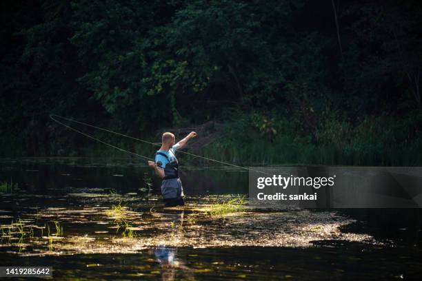 pêche à la mouche dans la rivière au lever du soleil - freshwater fishing stock photos et images de collection