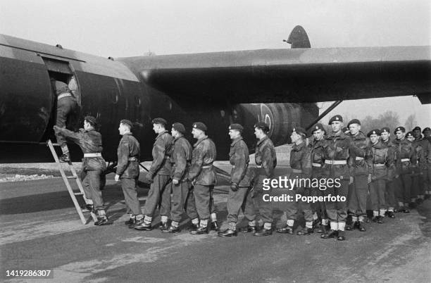 Troops from an airborne infantry division of the British Army line up to enter an Airspeed Horsa troop-carrying glider for a training flight from an...