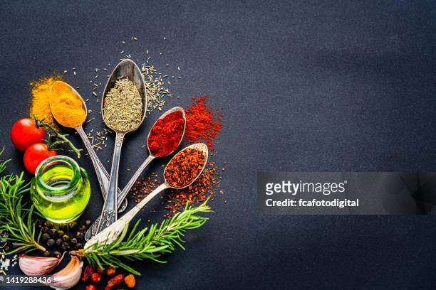 spices, condiments and herbs on black background. copy space - lowest stockfoto's en -beelden