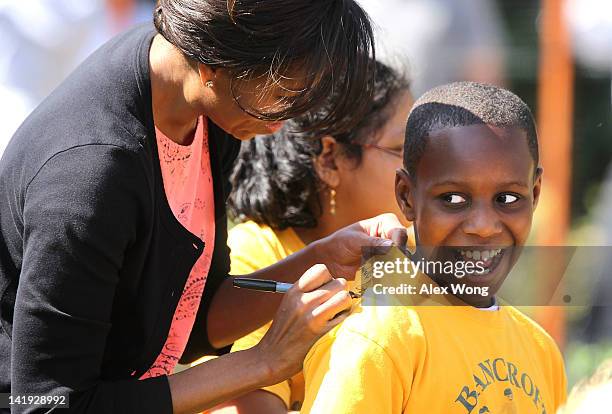 First lady Michelle Obama signs autograph on the T-shirt of Dylan Molineaux, a 4th grader of Bancroft Elementary School in DC, during the fourth...