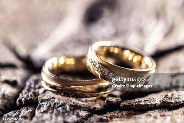 golden wedding rings on very old rustic oak table. - 結婚戒指 個照片及圖片檔